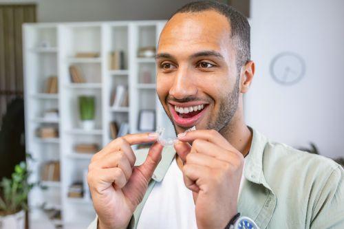 A man holding a clear aligner in Columbia, Md
