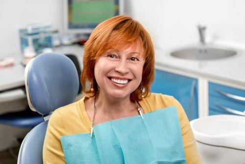 An elderly woman smiling after getting dental crown treatment in Columbia, Md